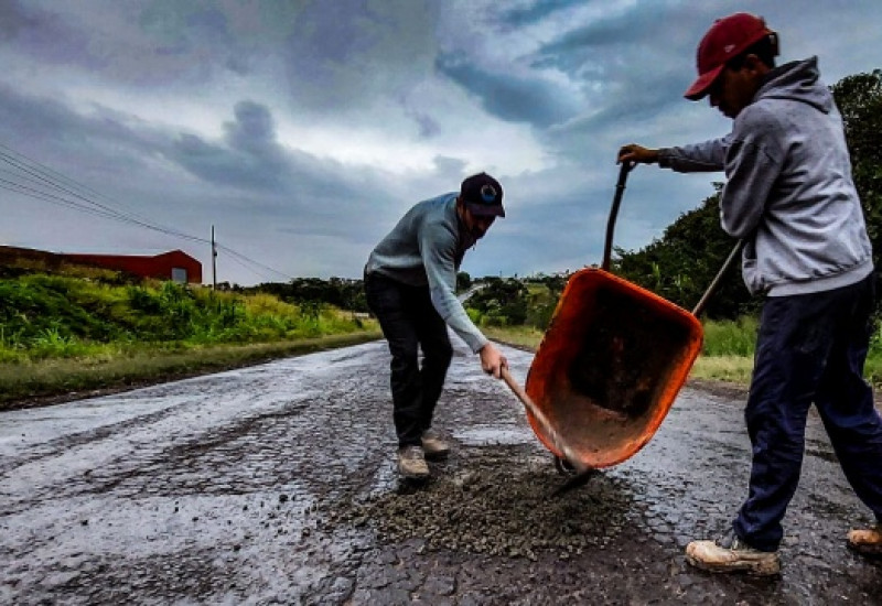 Cansados de esperar pelo fechamento dos buracos na BR-163, agricultor e três profissionais da construção civil colocaram a mão na massa (Foto: Marcos Lewe / Rádio 103 FM)
