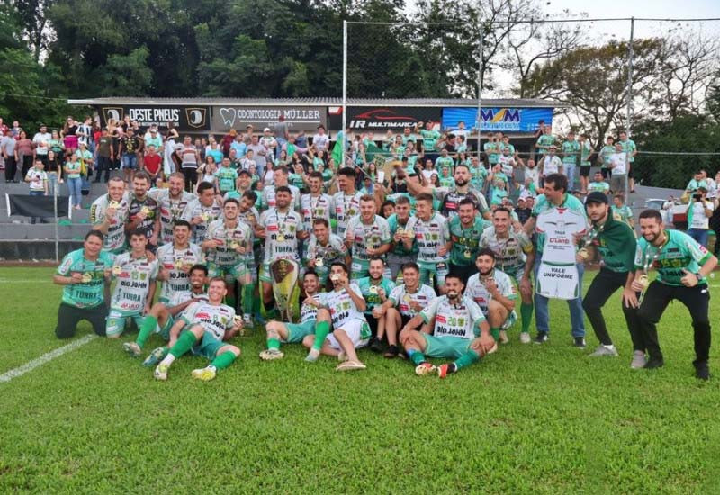 Com as medalhas e troféu, atletas e dirigentes comemoram a grande conquista (Foto: Rádio Progresso FM)